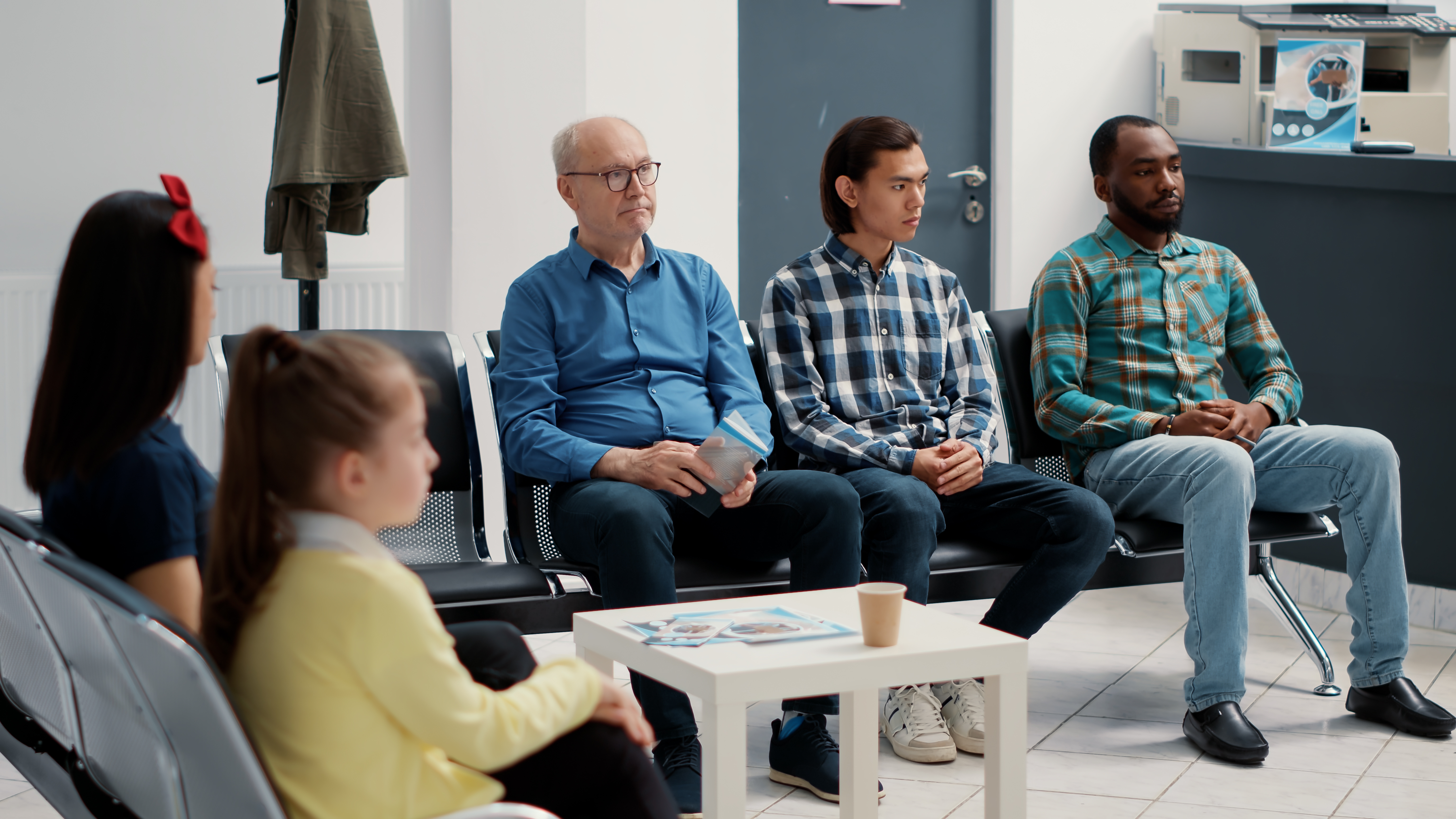 diverse-group-people-sitting-together-hospital-waiting-room-preparing-meet-with-general-practitioner-medical-clinic-different-patients-waiting-attend-appointment-tripod-shot-1